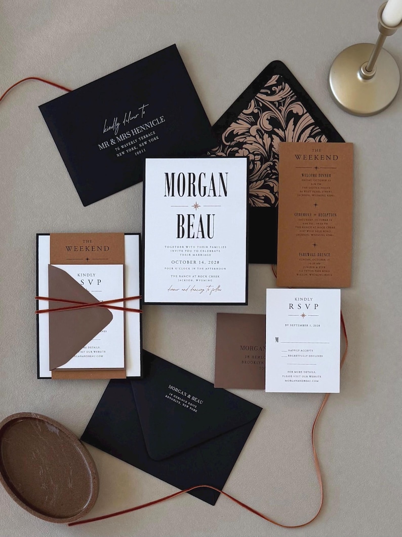 Modern brown, black and white Whitmore wedding invitation suite featuring bold typography, layered invitation, warm rust details card, RSVP card, black envelope and thin velvet ribbon.