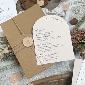 May include: A wedding invitation suite with a brown envelope, a white card with the text "All the Details" and a cream card with the text "Reception" and "Accommodations". The cream card has a wax seal with a floral design.