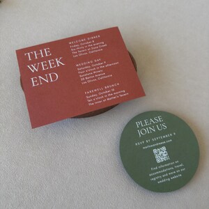 Terracotta wedding details card featuring bold ivory typography paired with the olive green QR code RSVP card from the modern Marlowe suite.