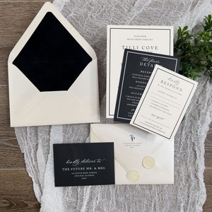 May include: Black and white wedding invitation suite with a black envelope, a white envelope with a black wax seal, and a black and white invitation card with the text "Tilli Cove" and "The finer details".
