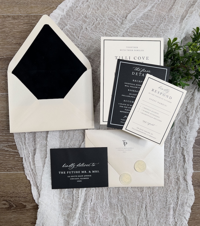 May include: Black and white wedding invitation suite with a black envelope, a white envelope with a black wax seal, and a black and white invitation card with the text "Tilli Cove" and "The finer details".