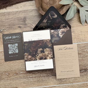May include: A wedding invitation suite featuring a dark floral envelope liner, a main invitation card with a floral belly band, a details card, and a response card with a QR code. The text includes Lighthouse Inn, West Dennis, Massachusetts.