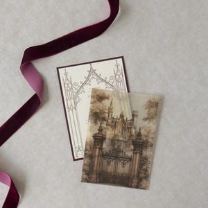 Illustrated Gothic castle entrance on translucent vellum displayed over a Wedding Cream invitation with Bitter Chocolate backing, styled with rich burgundy ribbon and antique architectural stationery details.
