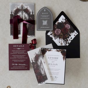 Video showing the Lenore Gothic wedding invitation suite being assembled, featuring a floral printed vellum jacket, white invitation with black backing, dark romantic rose artwork, and coordinating wedding stationery.