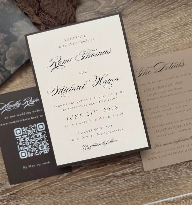 May include: A wedding invitation suite featuring a cream-colored main card with black serif and script text announcing the marriage of Romi Thomas and Michael Hayes on June 21st, 2028, at the Lighthouse Inn, accompanied by a dark brown RSVP card with a QR code.