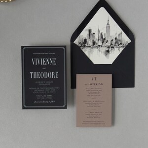 Black Vivienne wedding invitation displayed with coordinating envelope and black-and-white city skyline liner for a sophisticated modern city wedding.