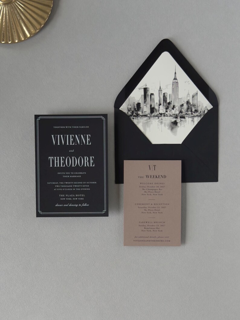 Black Vivienne wedding invitation displayed with coordinating envelope and black-and-white city skyline liner for a sophisticated modern city wedding.