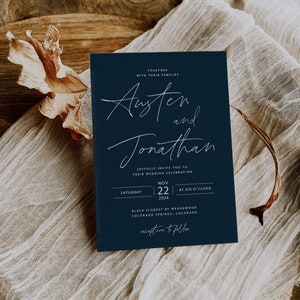 May include: A navy blue wedding invitation with white calligraphy for Austen and Jonathan. The invitation details the wedding date, time, and location: Saturday, November 22, 2024, at six o'clock, Black Florest by Wedgewood, Colorado Springs, Colorado. The invitation also includes the phrase "reception to follow".
