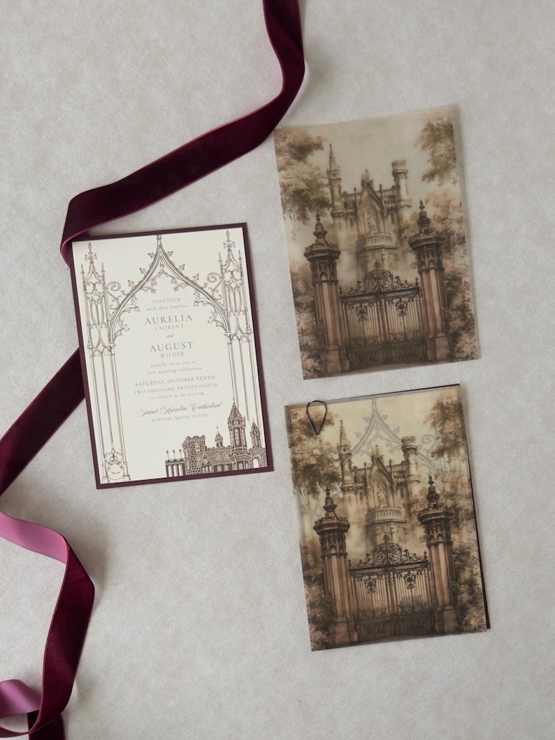 Gothic European castle wedding invitation layered with an ornate architectural vellum overlay, illustrated stone gates, Wedding Cream invitation with Bitter Chocolate backing, and rich burgundy velvet ribbon on a neutral textured background.