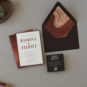 Modern rust and brown Ramona wedding invitation suite featuring a layered ivory invitation, dark chocolate RSVP card and artistic terracotta stationery details.