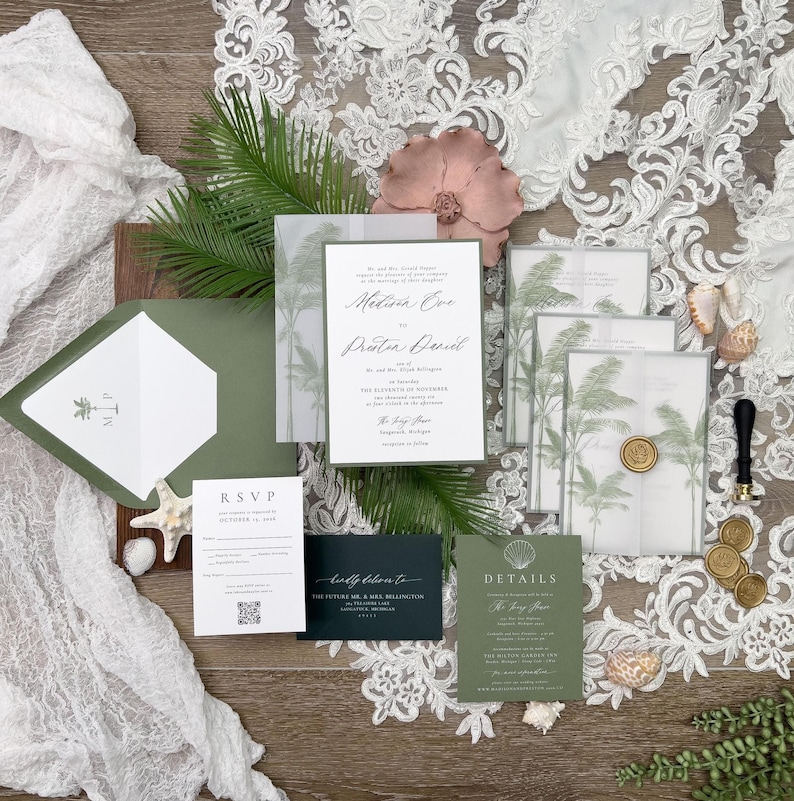 May include: An assortment of wedding stationery, including invitations, RSVP cards, and details cards, in shades of green and white. The invitations feature palm tree designs and elegant calligraphy. Decorative elements include seashells, a pink flower, and a wax seal.