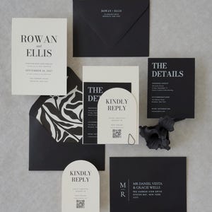 Black and ivory wedding invitation suite styled on a neutral textured background with elegant modern details