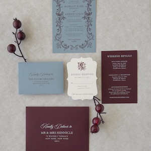 Romantic dusty blue wedding invitation with ornate border paired with deep burgundy details card and ivory scalloped RSVP
