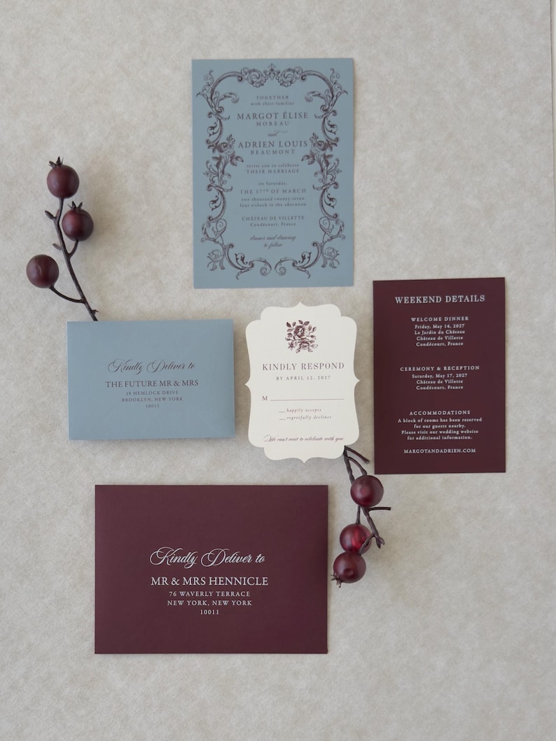 Romantic dusty blue wedding invitation with ornate border paired with deep burgundy details card and ivory scalloped RSVP