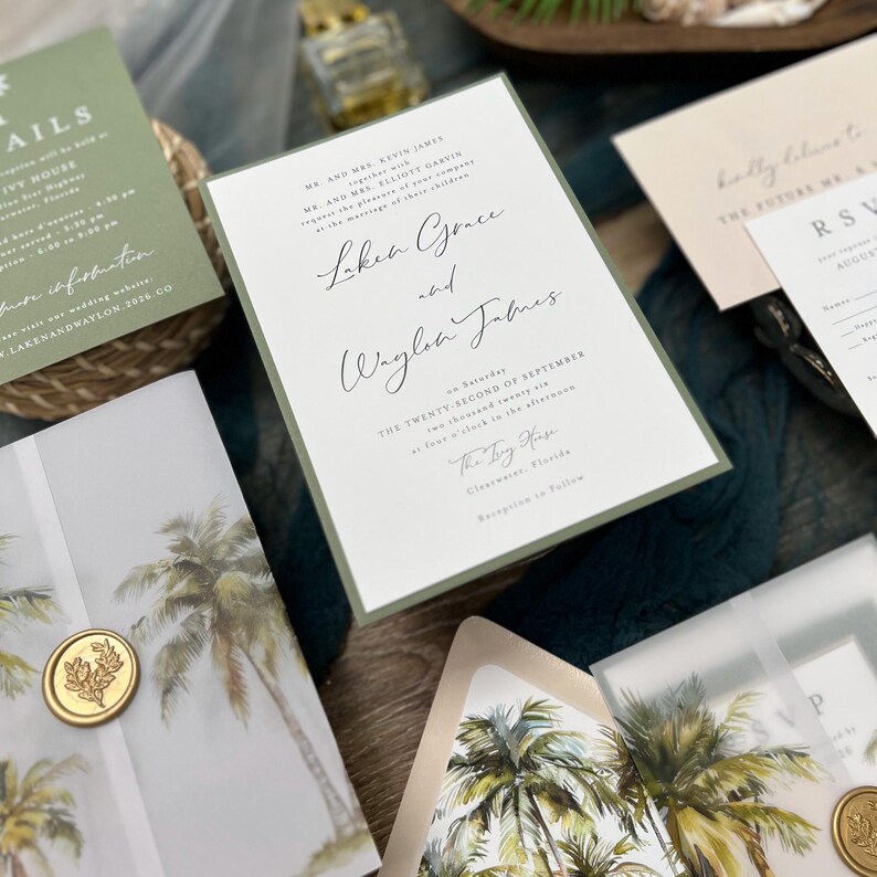 May include: A wedding invitation suite with a green and white color scheme. The invitation features the couple's names, "Laken Grace and Waylon James", and the date of their wedding, "The Twenty Second of September". The invitation is decorated with a palm tree design.