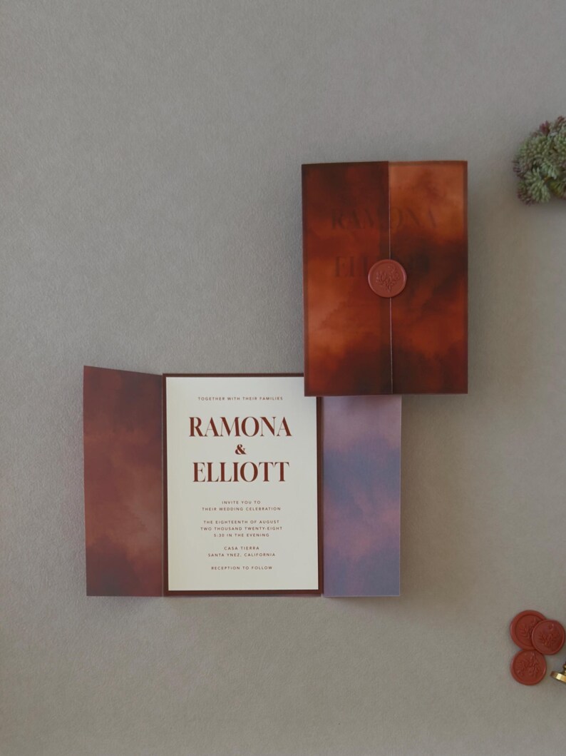 Modern rust and brown Ramona wedding invitation suite featuring a layered ivory invitation, dark chocolate RSVP card and artistic terracotta stationery details.