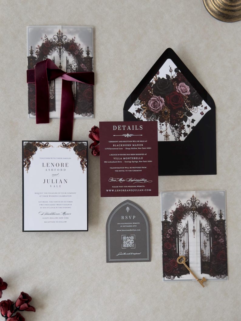 Lenore wedding invitation suite arranged with white invitation, Ebony backing mat, Claret details card, Dark Grey tombstone-shaped RSVP, illustrated floral vellum jacket, and black envelope with dramatic rose liner.