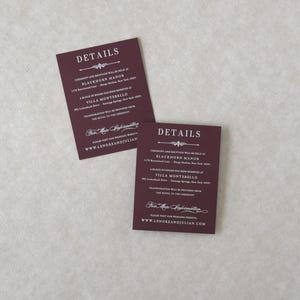 Two coordinating Claret burgundy wedding details cards featuring white ink-style typography, displaying reception and accommodation information for the Lenore Gothic floral wedding invitation suite.