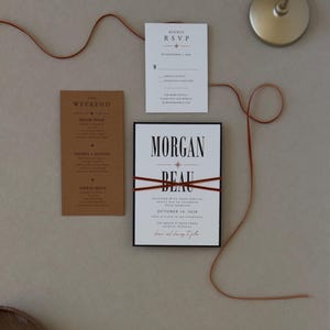 Modern wedding invitation with bold black typography paired with warm rust brown details cards, RSVP card and black stationery from the Whitmore invitation suite.