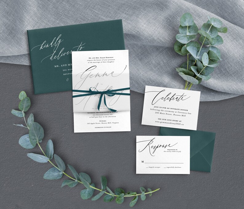 K&ouml;nnte beinhalten: Eine Hochzeitseinladungssuite mit einem gr&uuml;nen Umschlag, einer wei&szlig;en Einladung mit einem gr&uuml;nen Band und einer wei&szlig;en RSVP-Karte. Die Einladung zeigt den Text "Gemma & Andy" in Kalligraphie. Die RSVP-Karte tr&auml;gt den Text "Antwort" in Kalligraphie.