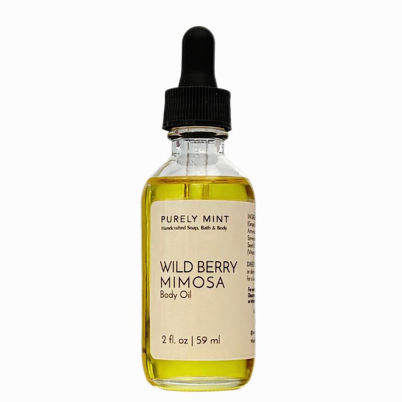 Wild Berry Mimosa body oil in glass bottle with white label and black dropper top, white background.