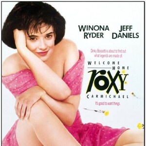 May include: Movie poster for "Welcome Home, Roxy Carmichael" featuring Winona Ryder and Jeff Daniels. The poster shows a woman in a pink dress and black boots with pink laces. Text includes the movie title and credits.