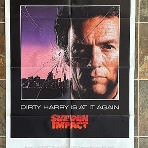 May include: A film poster for the movie "Sudden Impact" starring Clint Eastwood. The poster features a close-up of Clint Eastwood's face with a cityscape in the background. The text "Dirty Harry is at it again" is written in red letters below the image. The title of the film, "Sudden Impact", is written in red letters below the text.