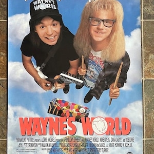 Peut inclure: Une affiche de film Wayne's World montrant deux personnes sur un ciel bleu nuageux. L'une porte une casquette noire Wayne's World et tient une guitare, l'autre a de longs cheveux blonds, des lunettes et tient des baguettes. Texte : You'll laugh. You'll cry. You'll hurl. WAYNE'S WORLD.