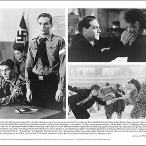 May include: Black and white photo of a scene from the movie "Swing Kids". The photo shows a group of young people dancing in a large hall. The photo also shows a scene of a young man in a Nazi uniform.