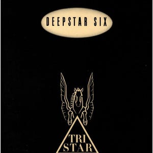 May include: Black background with the text "DEEPSTAR SIX" in a cream-colored oval. Below, a gold-colored logo of a winged horse above a triangle with "TRI STAR PICTURES" in cream.