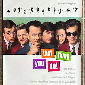May include: Movie poster for "That Thing You Do!" featuring a cast of six actors. The title is in colorful blocks. The poster includes the text "In every life there comes a time when that dream you dream becomes that thing you do."