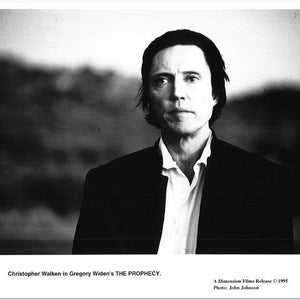 Puede incluir: Fotografía en blanco y negro del actor Christopher Walken. Viste una chaqueta oscura sobre una camisa blanca con cuello. La imagen incluye el texto "Christopher Walken in Gregory Widen's THE PROPHECY."