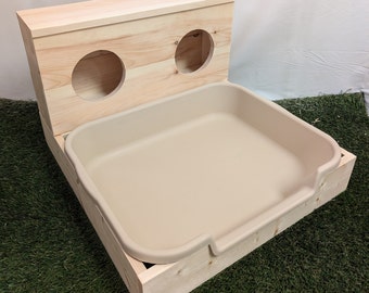 May include: A wooden pet bed with a removable beige plastic tray. The bed has two openings on the top for pets to enter.