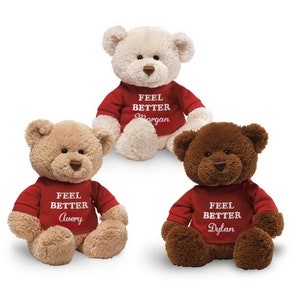 May include: Three plush teddy bears wearing red shirts with the text "Feel Better" and a name on each shirt. The names are Morgan, Avery, and Dylan.