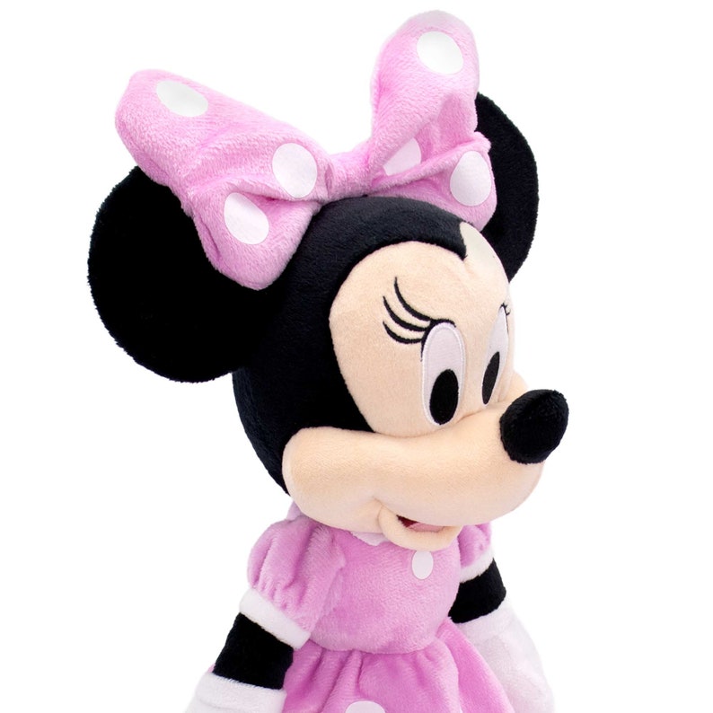 May include: A pink and black plush toy of Minnie Mouse wearing a pink bow with white polka dots and a pink dress with white polka dots.