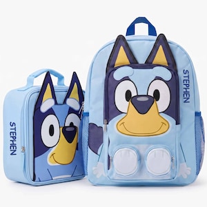 May include: A light blue backpack and matching lunch bag set featuring the character Bluey. Both items have the name STEPHEN printed in dark blue text. The backpack includes a top handle, side mesh pockets, and a front zippered compartment.