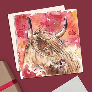 Könnte beinhalten: Aquarell-Grußkarte mit einem Highland-Rind mit langem, braunem Fell und gebogenen Hörnern. Der Hintergrund ist eine Lasur aus Rot, Orange und Gold. Eine Geschenkbox mit rotem Band und ein weißer Umschlag mit Herzaufkleber sind ebenfalls zu sehen.