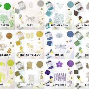 May include: A collection of 12 paint colors in small glass jars with labels. The colors are: Grass Green, Grey, Indian Aqua, Indian Mink, Indian Orange, Indian Yellow, Indigo, Khaki, Kiwi, Latte, Lavender, and Linen. Each color is displayed with a small sample of the paint on a card with a design.