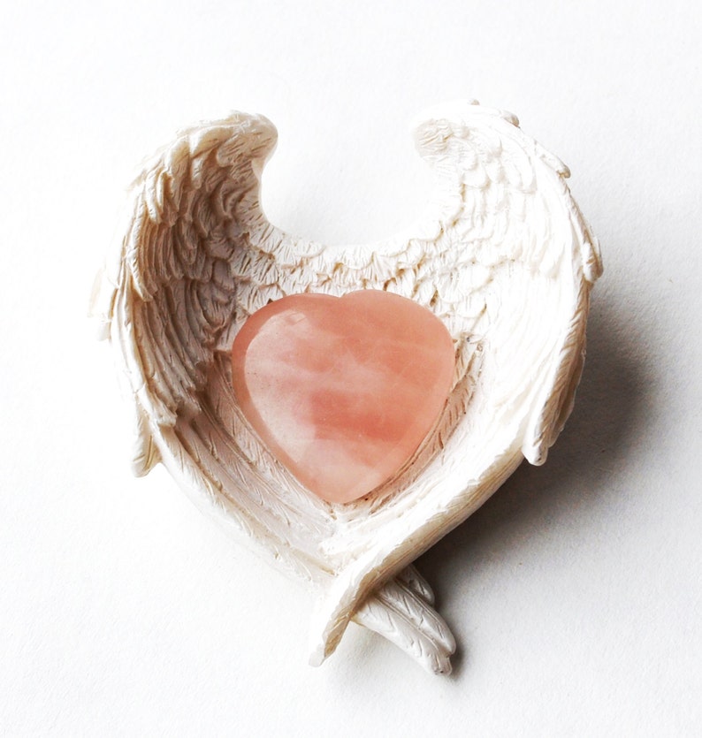 Rose quartz stone in angel wings dish.