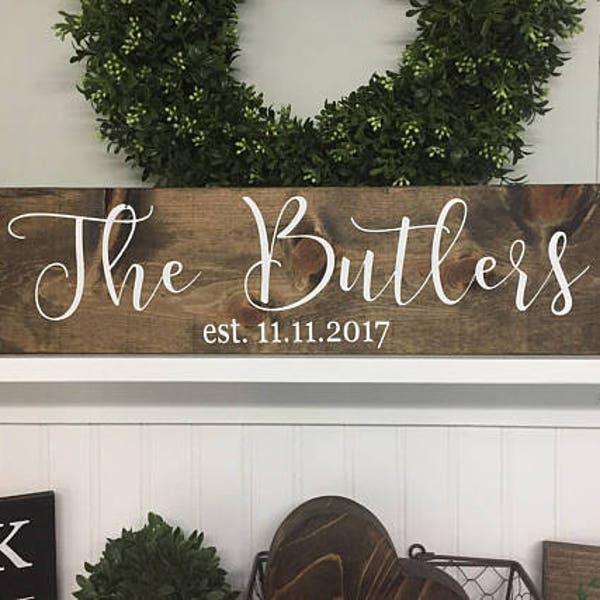 May include: A rustic wooden sign with the text "The Butlers est. 11.11.2017" in white cursive lettering.