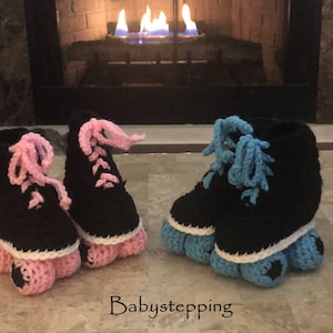 May include: Two pairs of crocheted baby roller skate booties. One pair is pink and the other is blue.