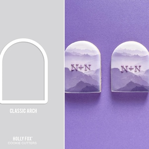 May include: A white plastic cookie cutter in the shape of a classic arch. Three cookies are shown decorated with purple icing and the letters N+N.