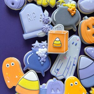 May include: A collection of Halloween-themed sugar cookies decorated with various designs, including ghosts, pumpkins, candy corn, a cauldron, a tombstone with the word "RIP" on it, and a shopping bag with a candy corn design.