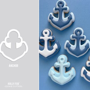 May include: A white anchor-shaped cookie cutter with the text ANCHOR and HOLLY FOX COOKIE CUTTERS below it, alongside five anchor-shaped cookies decorated in shades of blue and white with solid, striped, and gradient icing patterns.