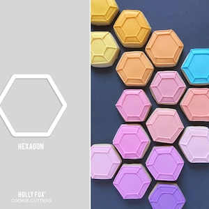 Puede incluir: Un cortador de galletas hexagonal blanco junto a una colección de galletas con forma de hexágono en varios colores, incluyendo amarillo, naranja, rosa y azul. Las galletas tienen un diseño geométrico. El texto "HEXAGON" y "HOLLY FOX COOKIE CUTTERS" también son visibles.