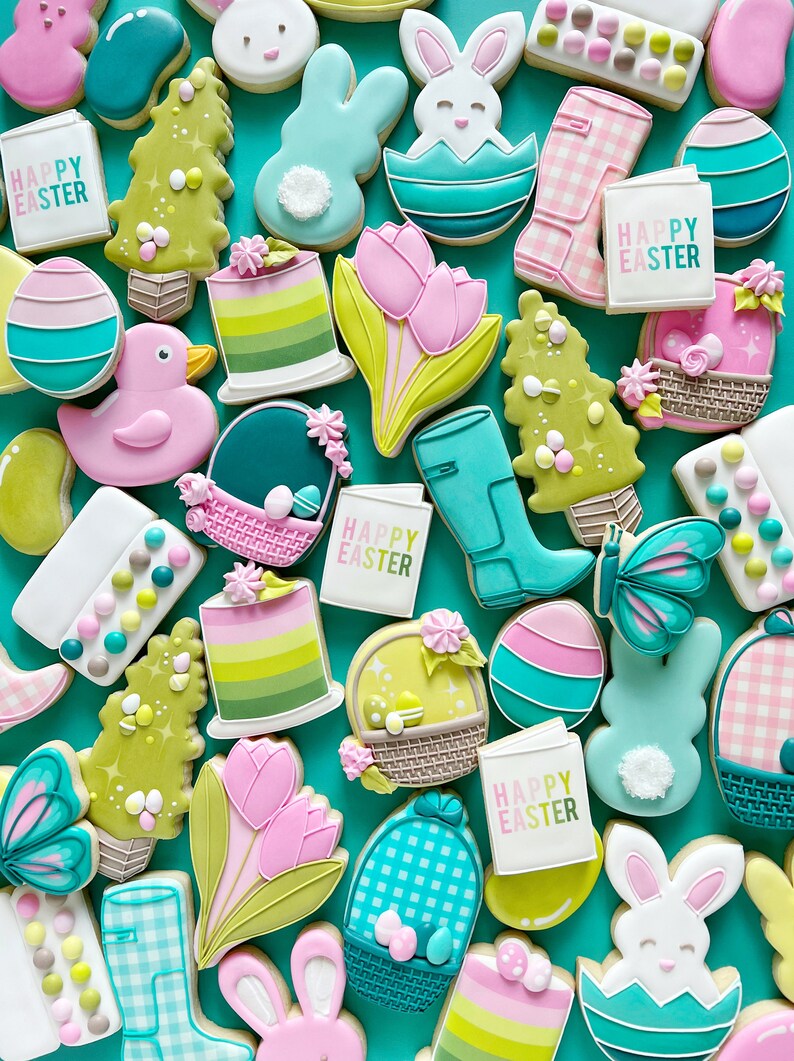 May include: A collection of colorful Easter-themed sugar cookies decorated with various designs, including bunnies, eggs, flowers, and the phrase "Happy Easter".