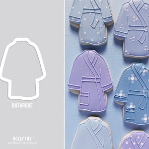 May include: A set of six cookie cutters shaped like bathrobes. The cutters are in various shades of blue and purple. The cutters are arranged in a row on a blue background. The text "Bathrobe" is printed below the cutters.
