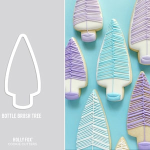 May include: A cookie cutter in the shape of a Christmas tree with a bottle brush design. The cutter is white and is shown against a gray background. The text "Bottle Brush Tree" is below the cutter. The text "Holly Fox Cookie Cutters" is below the text "Bottle Brush Tree".