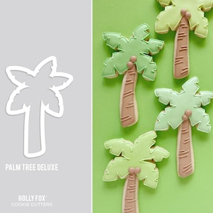 May include: A set of four green palm tree cookie cutters. The cutters are made of metal and have a detailed design. The text "Palm Tree Deluxe" and "Holly Fox Cookie Cutters" is visible on the image.