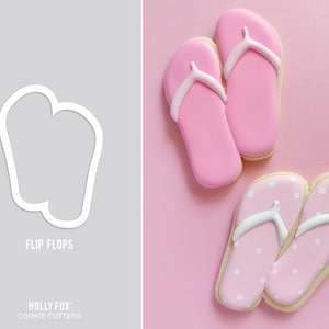 Peut inclure: Un emporte-pièce et des biscuits décorés en forme de tongs. L'emporte-pièce est blanc et le texte "FLIP FLOPS" est en dessous. Deux paires de biscuits tongs roses sont présentées, une paire à pois blancs.